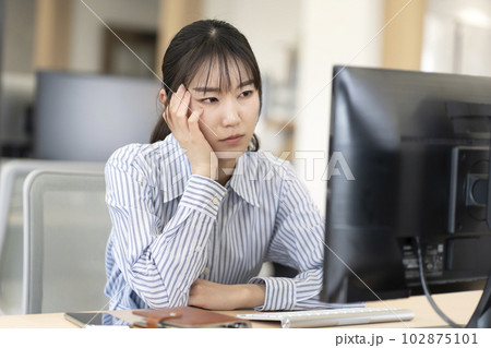 仕事中に頭痛が辛い女性 仕事中に頭痛が辛い女性 102875101