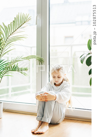 Lonely sad girl near the window. 102875513