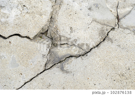 Cracks in the surface of a road or building wall caused by an earthquake 102876138