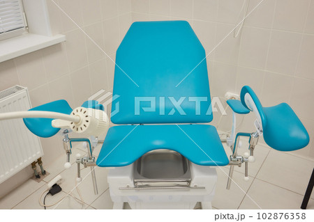 Gynecological cabinet with chair and medical equipment. 102876358