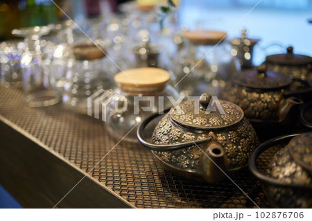 Eco-friendly dishes. Empty glass cup and teapot with wooden lid on wicker tablemat. Eco-friendly dishes. Empty glass cup and teapot with wooden lid on wicker tablemat. 102876706