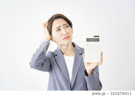 電卓を持って頭を抱えるビジネスウーマン　白背景 102876911