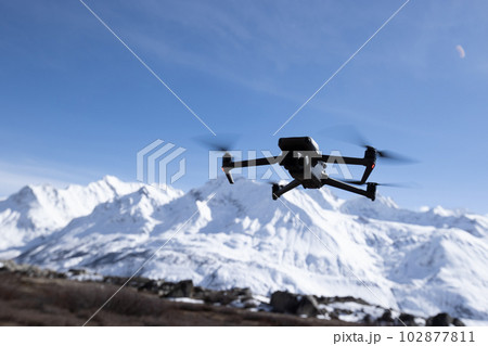 Flying drone in high altitude snow mountains 102877811