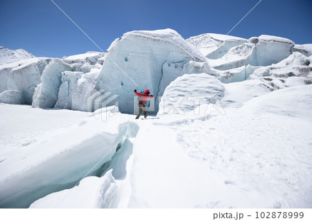 Woman hiker hiking in winter glacier mountains,China 102878999
