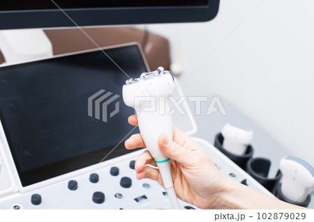 Woman doctor's hand aholding a medical gel to ultrasonic sensor of ultrasound machine in the clinic Woman doctor's hand aholding a medical gel to ultrasonic sensor of ultrasound machine in the clinic 102879029