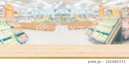 Wood table top with supermarket grocery store blurred defocused background with bokeh light for product display Wood table top with supermarket grocery store blurred defocused background with bokeh light for product display 102880331
