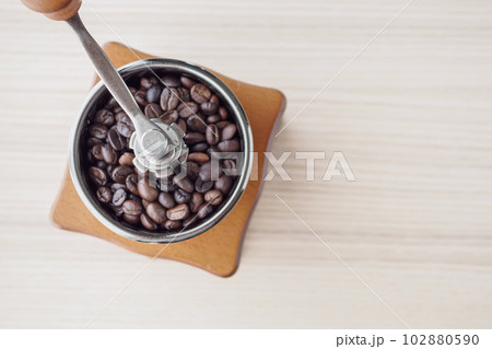 Vintage manual coffee grinder with roasted coffee beans Vintage manual coffee grinder with roasted coffee beans 102880590