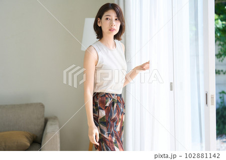 リビングで佇むおしゃれな若い女性 リビングで佇むおしゃれな若い女性 102881142