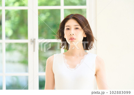 窓際で日差しを浴びる若い女性 窓際で日差しを浴びる若い女性 102883099