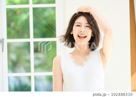 窓際で日差しを浴びる若い女性 102886310