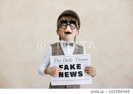 Newsboy shouting against grunge wall background. Boy selling fake news 102886469