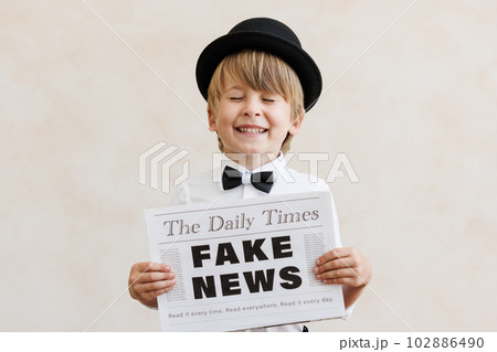 Newsboy shouting against grunge wall background. Boy selling fake news 102886490