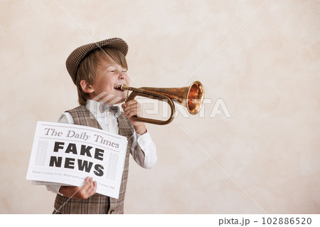 Newsboy shouting against grunge wall background. Boy selling fake news 102886520