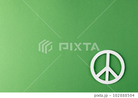 High angle view of white peace sign with copy space on green background 102888504
