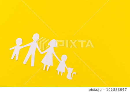 White paper cut out of family with two children and ca and copy space on yellow background 102888647