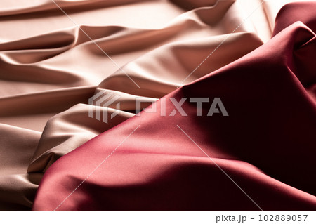 Close up of plain beige and red satin fabric with folds, copy space Close up of plain beige and red satin fabric with folds, copy space 102889057