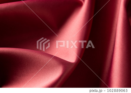 Close up of plain red satin fabric with folds, copy space Close up of plain red satin fabric with folds, copy space 102889063