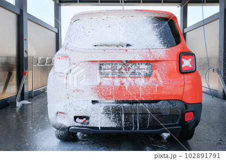 Car in foam at a car wash close-up. Car wash with soap 102891791