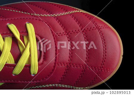 The texture of a red sneaker closeup. Part of leather sports shoes 102895013
