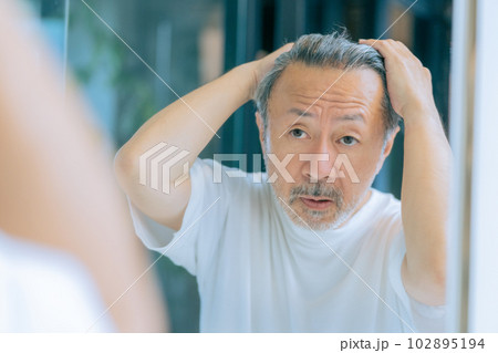 髪の毛を気にするミドルエイジの男性 102895194
