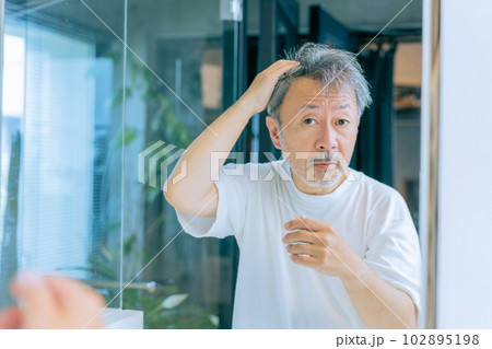 髪の毛を気にするミドルエイジの男性 髪の毛を気にするミドルエイジの男性 102895198