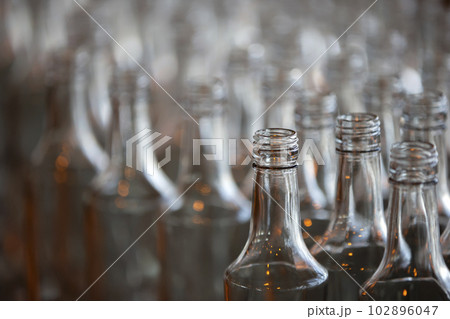 Glassworks. Glass industry. Many glass bottles on a factory conveyor. Glassworks. Glass industry. Many glass bottles on a factory conveyor. 102896047