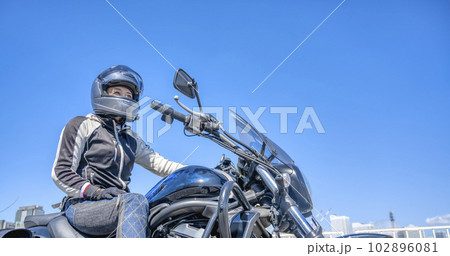 大型アメリカンバイクで横浜をツーリングする笑顔の女性ライダー 102896081