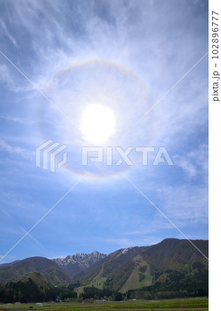 《長野県》春の白馬村　残雪の後立山連峰と新緑の山麓上空に現れたハロ・日暈 102896777