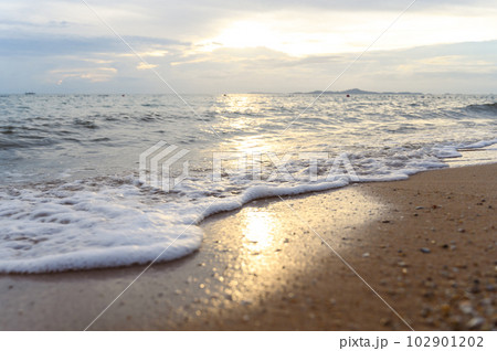 Seawater soft wave crashing on sandy beach seaside in summer on sunset time. summer vacation activity background concept.. 102901202
