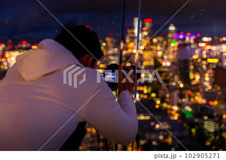 Tourist are trying to photograph the bright light Seattle city through the glass window. Tourist are trying to photograph the bright light Seattle city through the glass window. 102905271