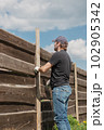 An adult man is engaged in carpentry work at a house construction site 102905342