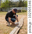 Man builds sections of fence around his yard out of planks 102905346