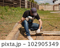 Man builds sections of fence around his yard out of planks 102905349