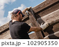Man builds sections of fence around his yard out of planks 102905350