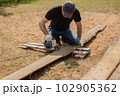 Man builds sections of fence around his yard out of planks 102905362