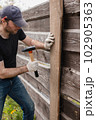 An adult man is engaged in carpentry work at a house construction site 102905363