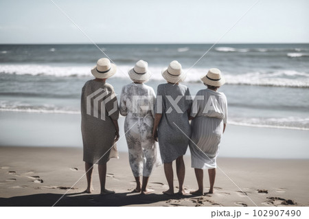 Elderly people enjoy company on sunny summer beach 102907490