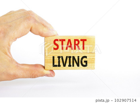 Start living symbol. Concept words Start living on beautiful wooden block. Beautiful white table white background. Businessman hand. Business and Start living concept. Copy space. 102907514