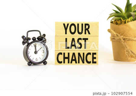 Time to your last chance symbol. Concept words Your last chance on wooden blocks on a beautiful white table white background. Black alarm clock. Business and your last chance concept. Copy space. 102907554