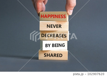 Happiness symbol. Concept words Happiness never decreases by being shared on wooden block. Businessman hand. Beautiful grey table grey background Motivational Happiness concept. Copy space. 102907620