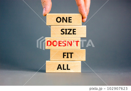 One size does not fit all symbol. Concept words One size does not fit all on wooden blocks. Businessman hand. Beautiful grey background. One size does not fit all business concept. Copy space. 102907623