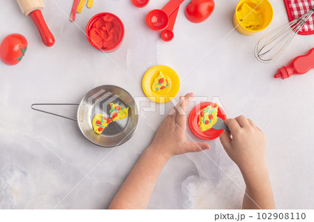 Boy's hands are making pizza with play dough. Kid's plasticine craft for art lesson. 102908110
