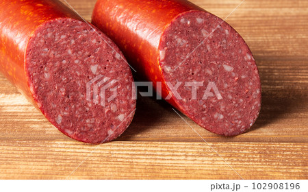 Sliced salami sausage on cutting board closeup. Food preparation idea before the holiday 102908196