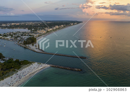 Aerial view of Nokomis beach and South and North Jetty in Sarasota County, USA. Many people enjoing vacation time swimming in gulf water and relaxing on warm Florida sun at sunset Aerial view of Nokomis beach and South and North Jetty in Sarasota County, USA. Many people enjoing vacation time swimming in gulf water and relaxing on warm Florida sun at sunset 102908863