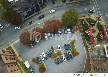 Aerial view of many colorful cars parked on parking lot on apartment building backyard. Place for vehicles in front of residential condo 102908894