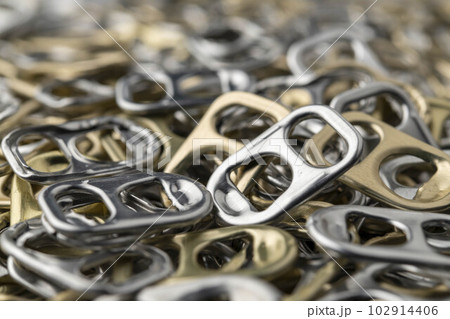 沢山並べたアルミ製のプルタブ 102914406