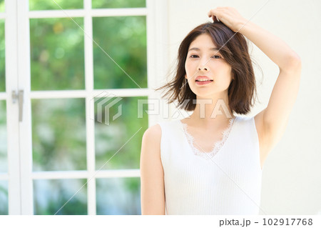 窓際で日差しを浴びる若い女性 102917768