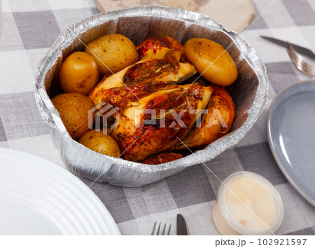 on table in baking dish is ready-to-eat fried chicken with potatoes in skin on table in baking dish is ready-to-eat fried chicken with potatoes in skin 102921597