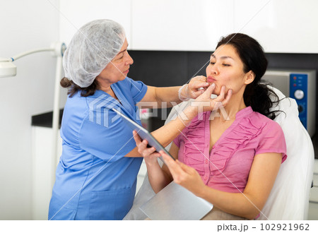 Cosmetologist planning upcoming lip reshaping procedures for female patient Cosmetologist planning upcoming lip reshaping procedures for female patient 102921962