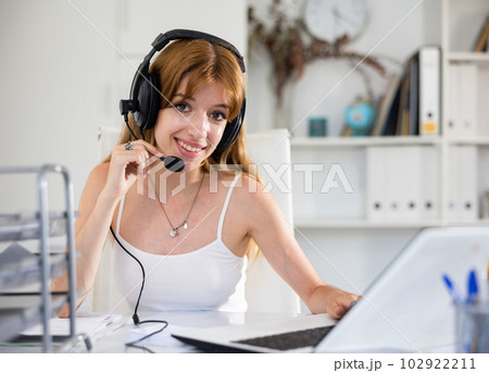 Cheerful woman with headset working in call center 102922211